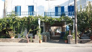 Un edificio blanco con contraventanas azules y fachada de piedra.