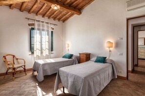 Una habitación con dos camas, una silla y un armario de madera.