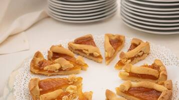 A table with stacks of plates and a plate of sliced pie.