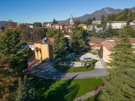 Un quartiere residenziale con un cortile centrale, circondato da case e alberi.