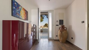 Ein Flur mit einem roten Schrank, einer großen Vase und einem farbenfrohen abstrakten Gemälde.