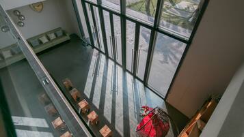 Un interior moderno con una zona de estar, ventanas amplias y una silla decorativa.