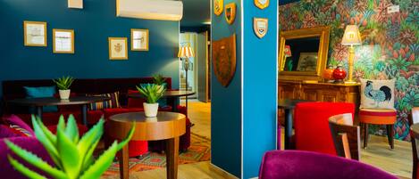 A room with a blue wall, wooden furniture, and a colorful floral wallpaper.