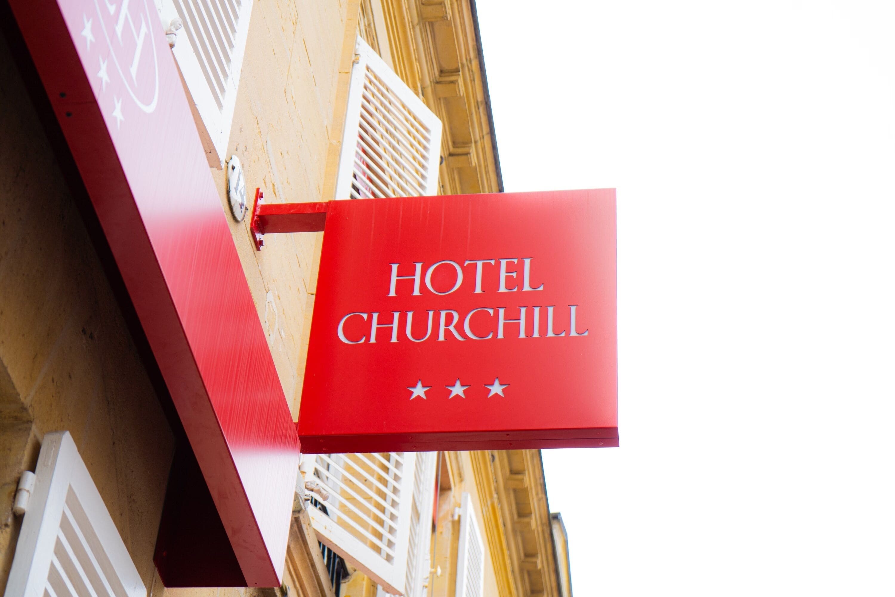 A red sign with "HOTEL CHURCHILL" written on it.