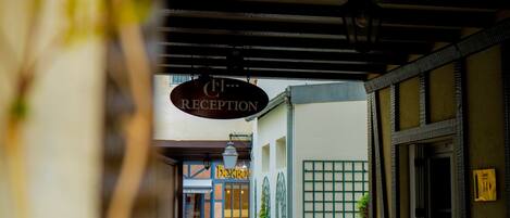 A reception area with a sign, a building entrance, and a window with a grid pattern.