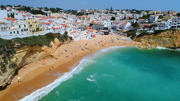 A coastal town with a beach, buildings, and a cliff. - Casa Scarlett, Walk to beach, Communal Pool (Carvoeiro)