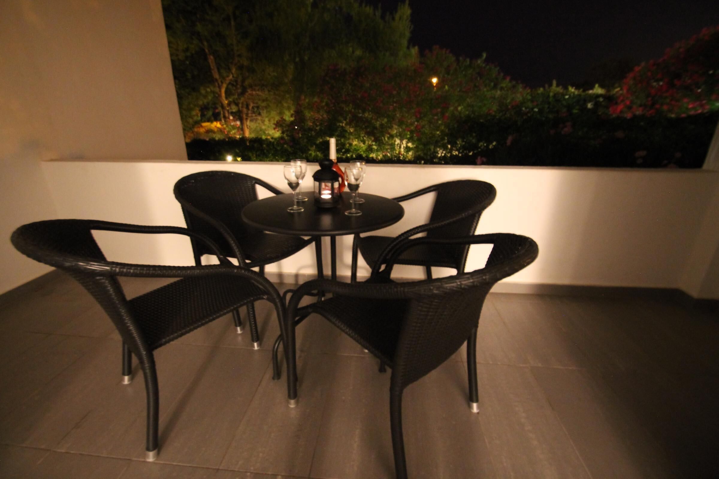 Een ronde tafel met vier stoelen op een balkon.