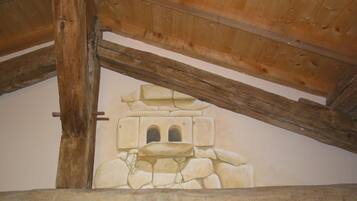 A rustic wooden ceiling with exposed beams and a stone wall mural.