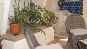 Una habitación acogedora con sillones de mimbre, chimenea y pared de azulejos.