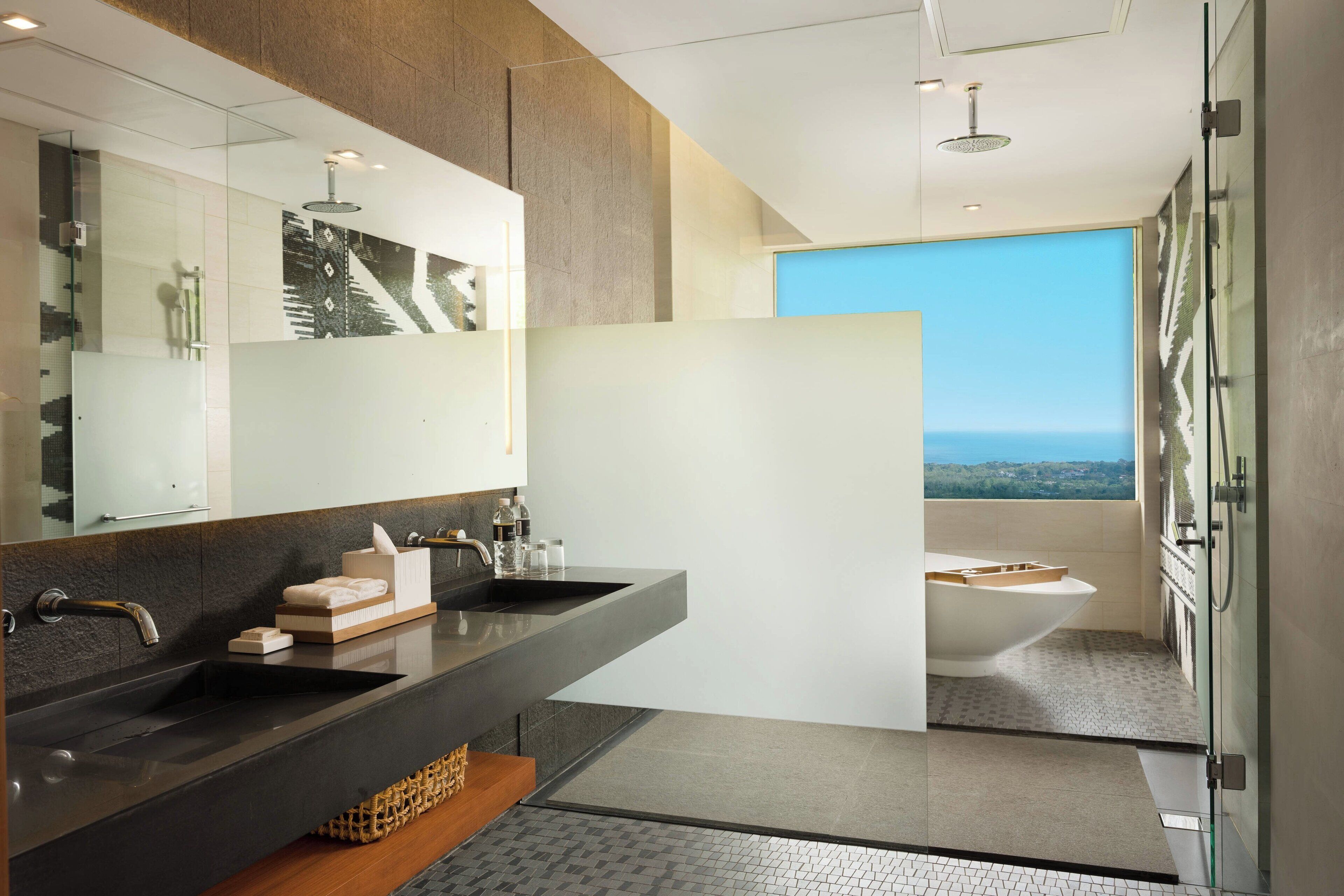 A modern bathroom with a large mirror, a bathtub, and a shower.
