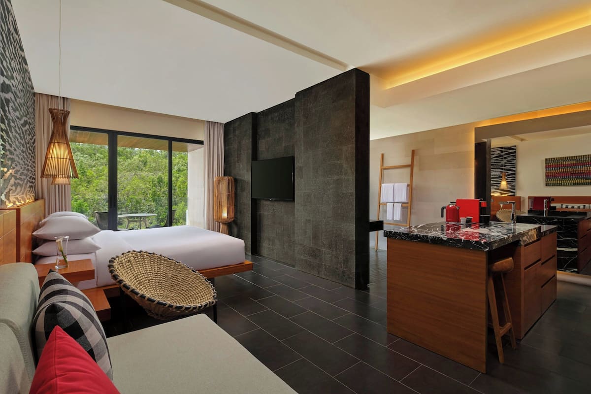 A modern hotel room with a large bed, a dining area, and a TV.