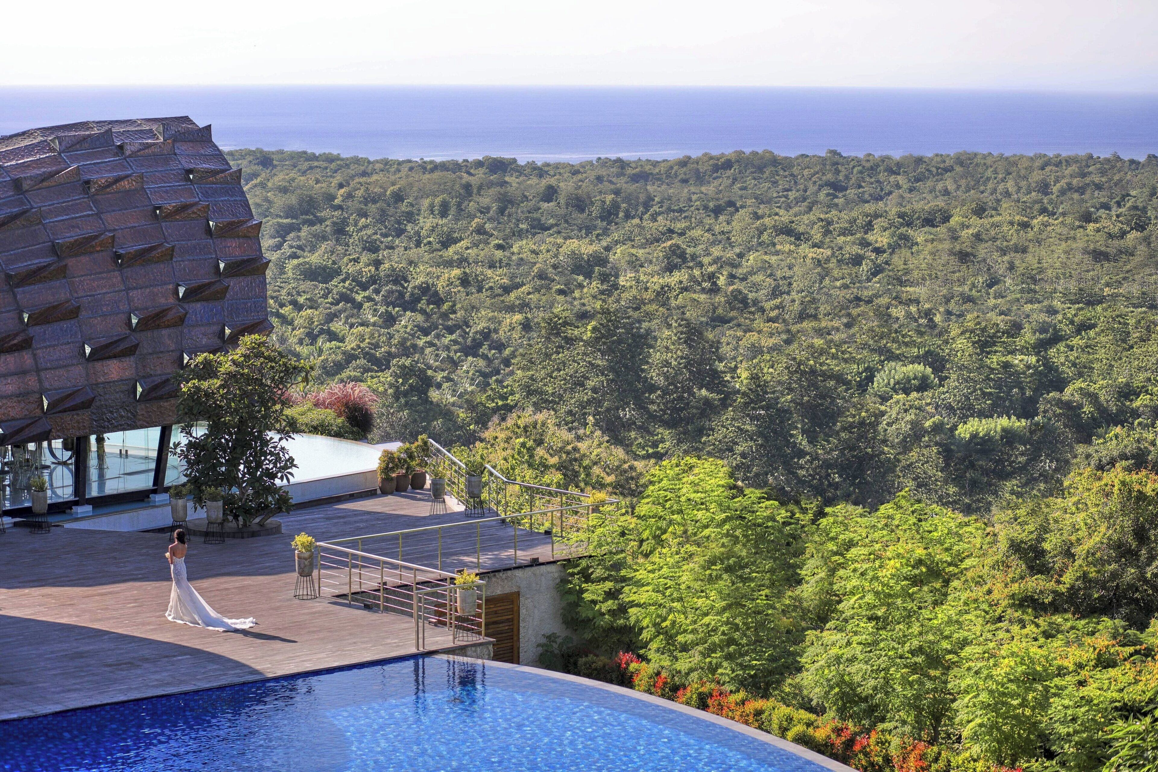 Un espace aménagé au bord de la piscine, offrant une vue sur un paysage boisé.