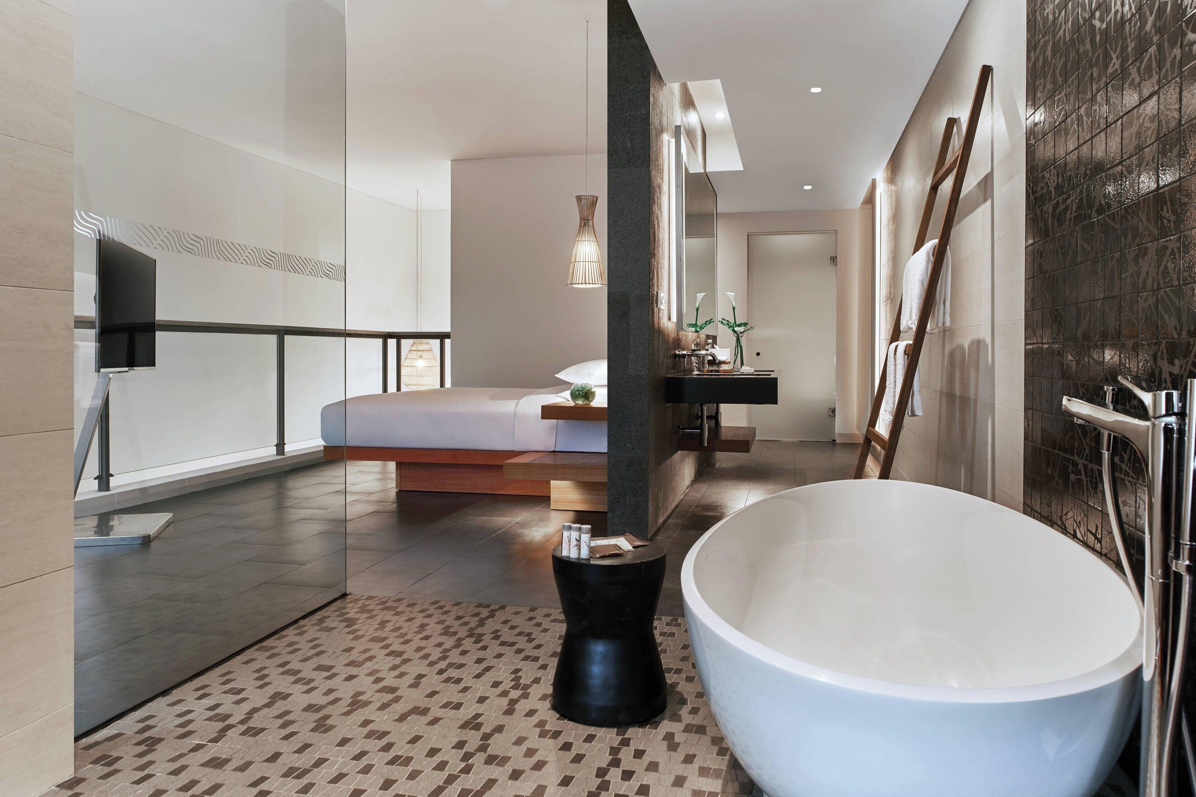 A modern bathroom with a large bathtub, a glass shower enclosure, and a minimalist design.