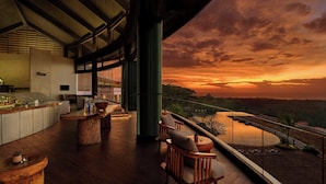 A modern bar area with a view of a sunset over a body of water. - Renaissance Bali Uluwatu Resort & Spa (Ungasan)