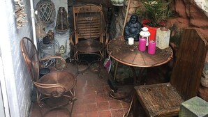 A rustic outdoor seating area with a table, chairs, and a decorative umbrella. - Stoneway Guest House (Bridgnorth)