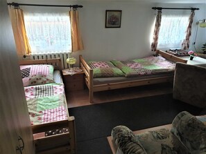 Una habitación acogedora con dos camas de madera, una mesita y una silla.