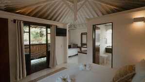 Une chambre avec un grand lit, un plafond en bois, un balcon et une salle de bain équipée d’un miroir et d’un lavabo.
