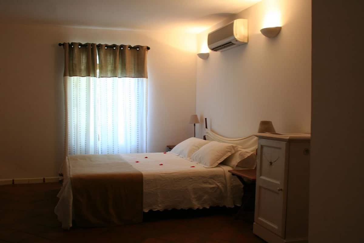 Ein Schlafzimmer mit einem Bett, einem Nachttisch, einer Lampe und einem Kleiderschrank.