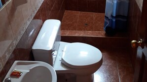 A small bathroom with a toilet, sink, and shower. - Hostal Vista Waynapata (Machu Picchu)
