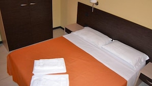 A hotel room with a bed, a nightstand, a lamp, and a wardrobe. - La Marina residence club (Pietrapaola)