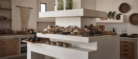 A modern kitchen with white cabinetry, multiple shelves, and various kitchenware.