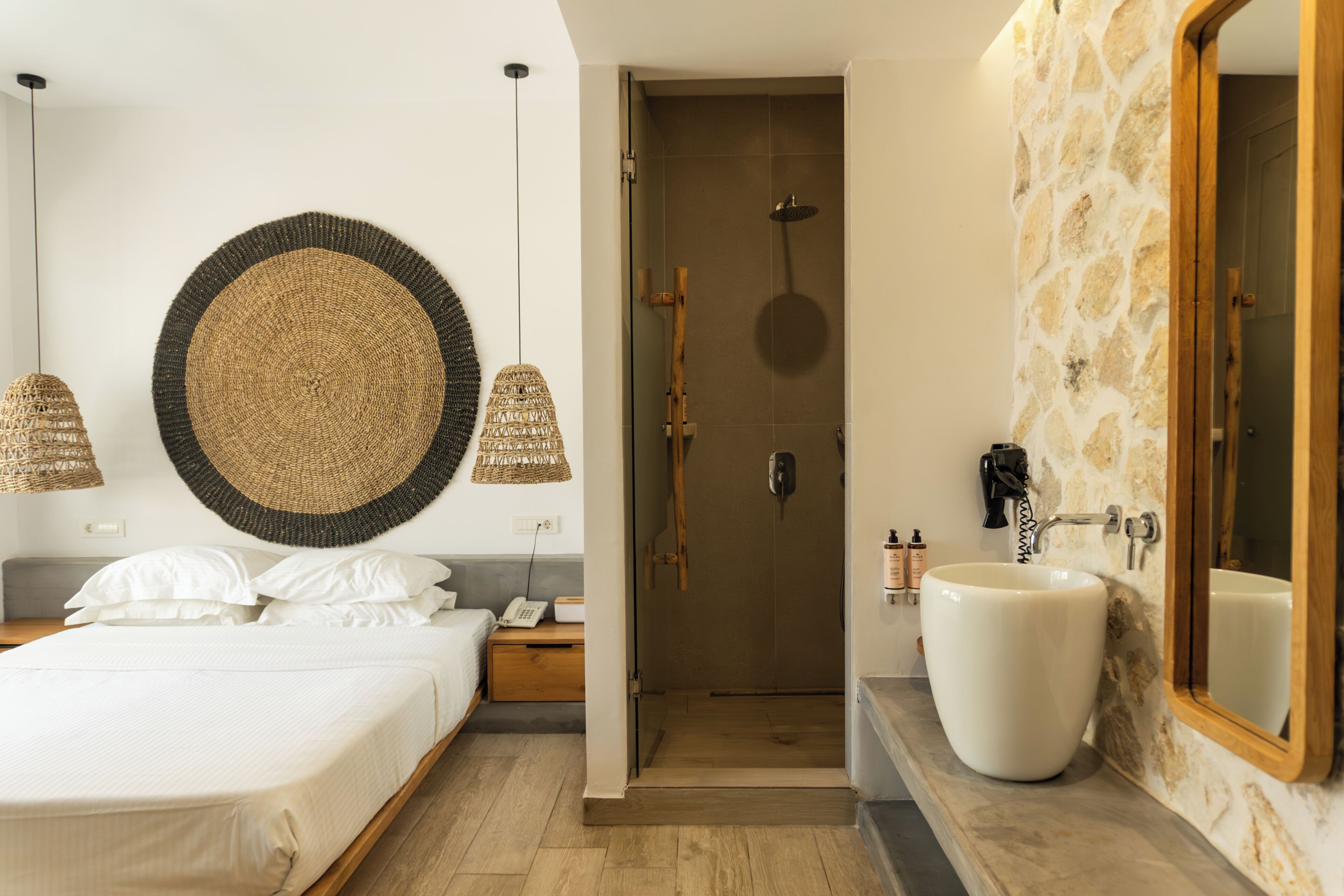 Un baño moderno con un espejo grande, un lavamanos blanco y una zona de ducha.