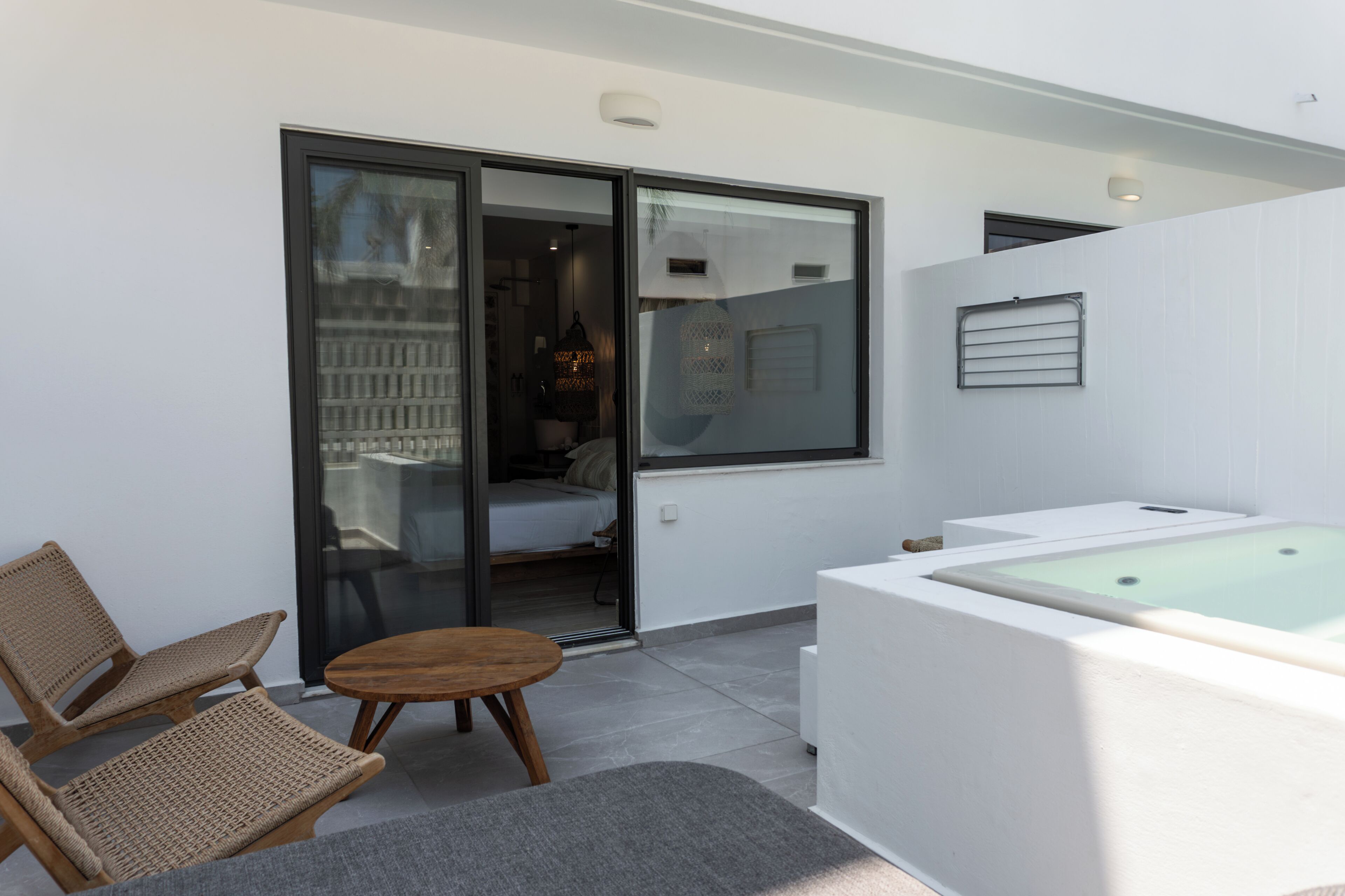 Une salle de bain moderne équipée d’une baignoire, d’une douche et de toilettes. On y trouve également un petit coin salon avec une table et des chaises.