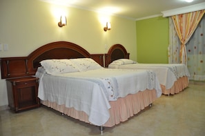 A hotel room with two beds, wooden headboards, and a nightstand. - Hotel El Caimito (Villavicencio)