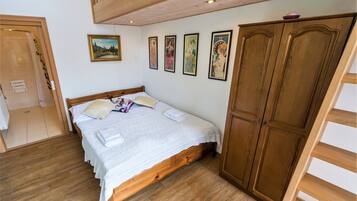 A bedroom with a wooden bed, a wardrobe, and a painting on the wall.