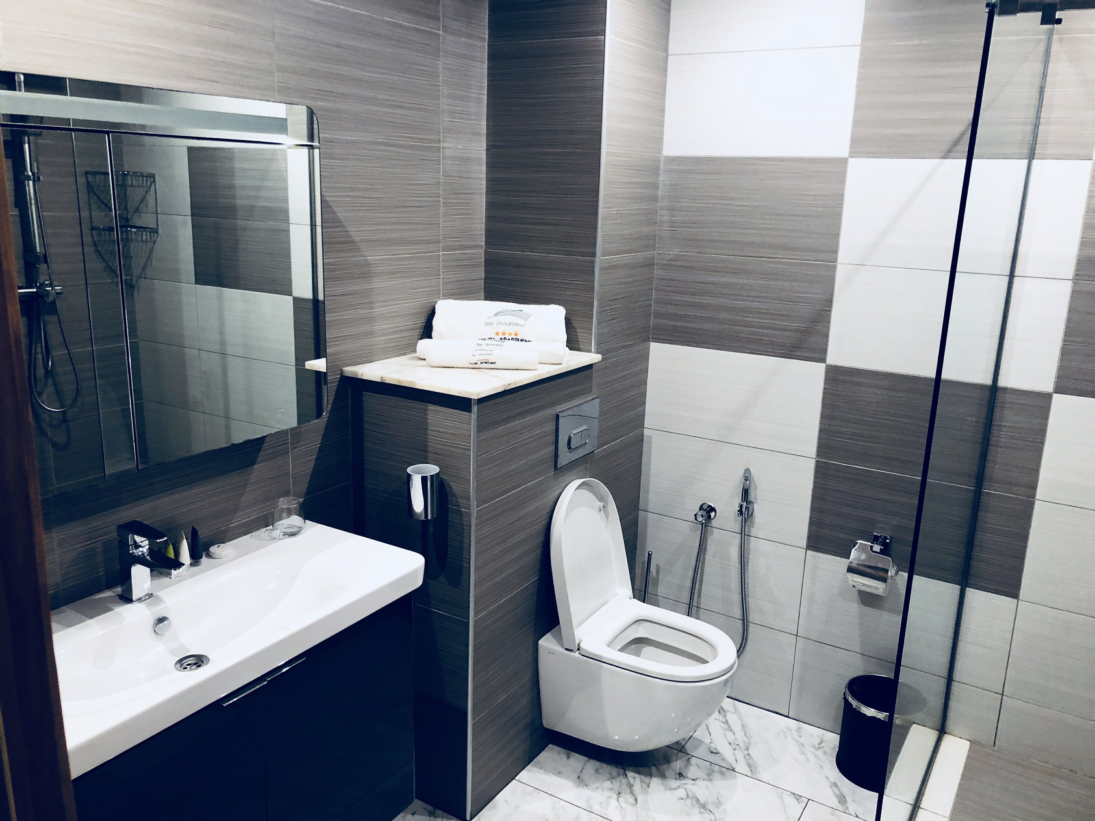 Une salle de bain moderne avec un lavabo blanc, des toilettes et un espace douche.