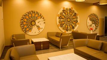 A modern lounge area with sofas and a coffee table, featuring three large circular wall art pieces.