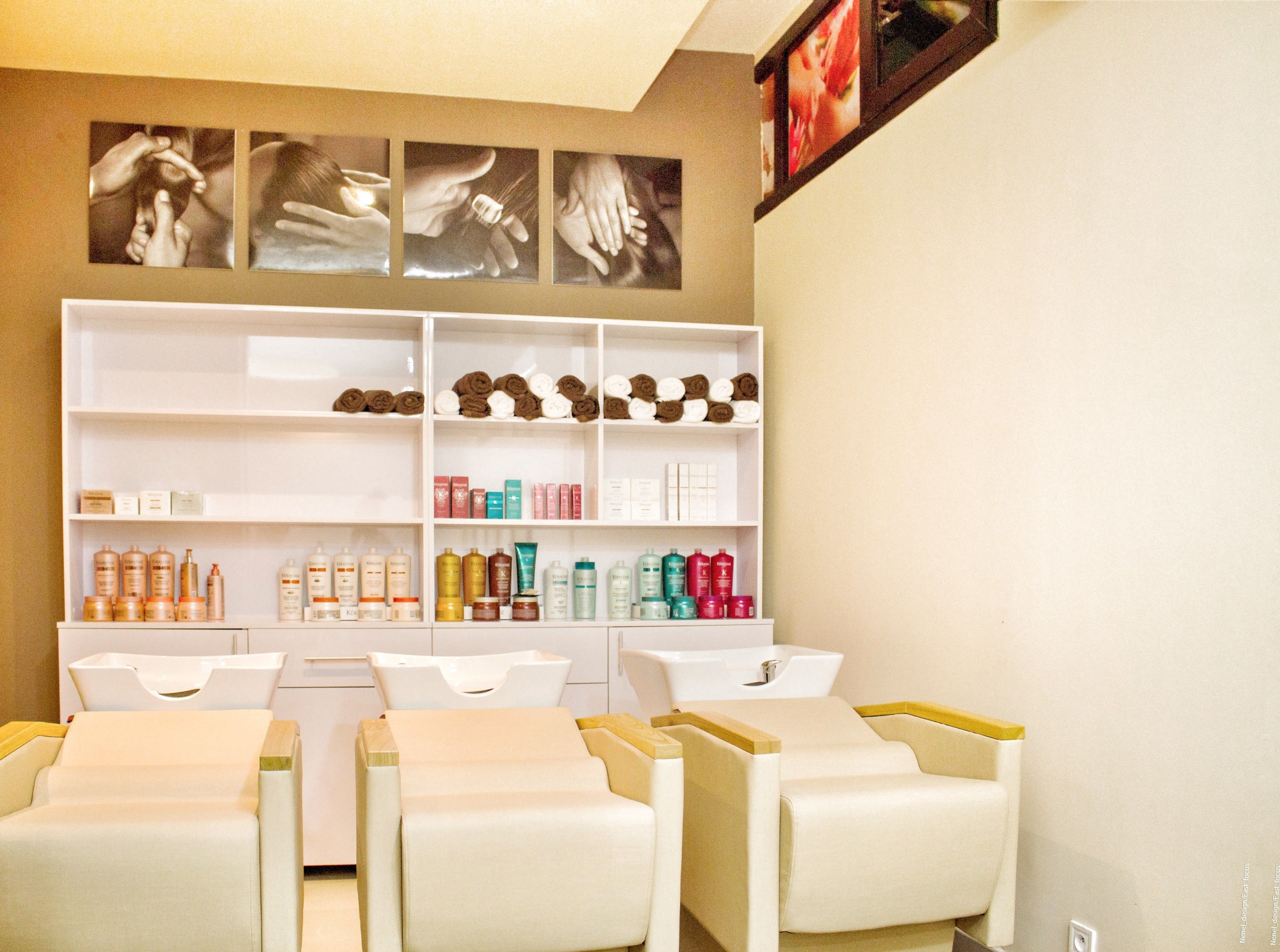 A spa room with a reception desk, a shelf with toiletries, and a wall with framed pictures.