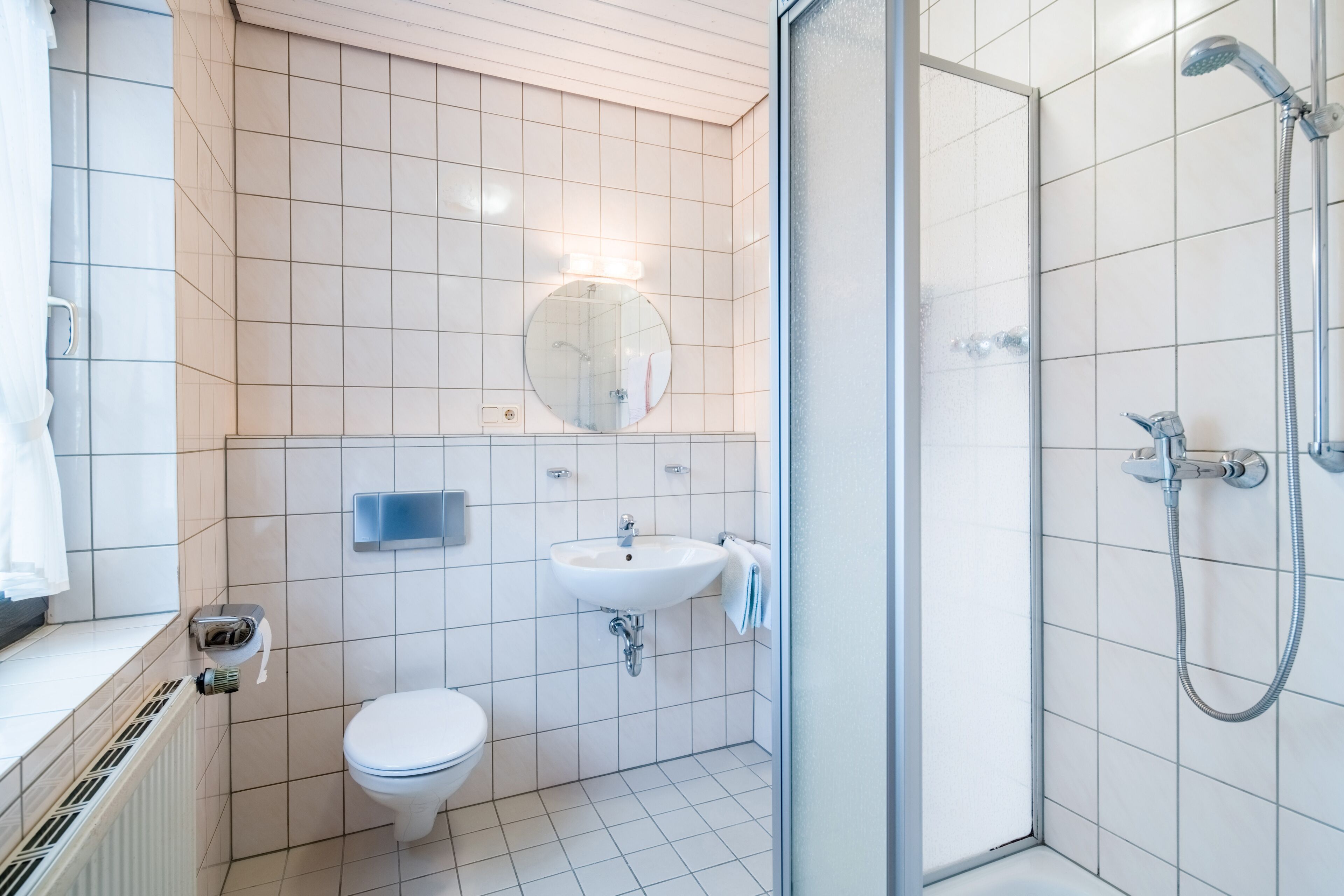 A modern bathroom with a toilet, sink, and shower.