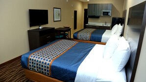 A hotel room with two beds, a desk, a television, a microwave, and a refrigerator. - Americas Best Value Inn & Suites Prairieville (Prairieville)