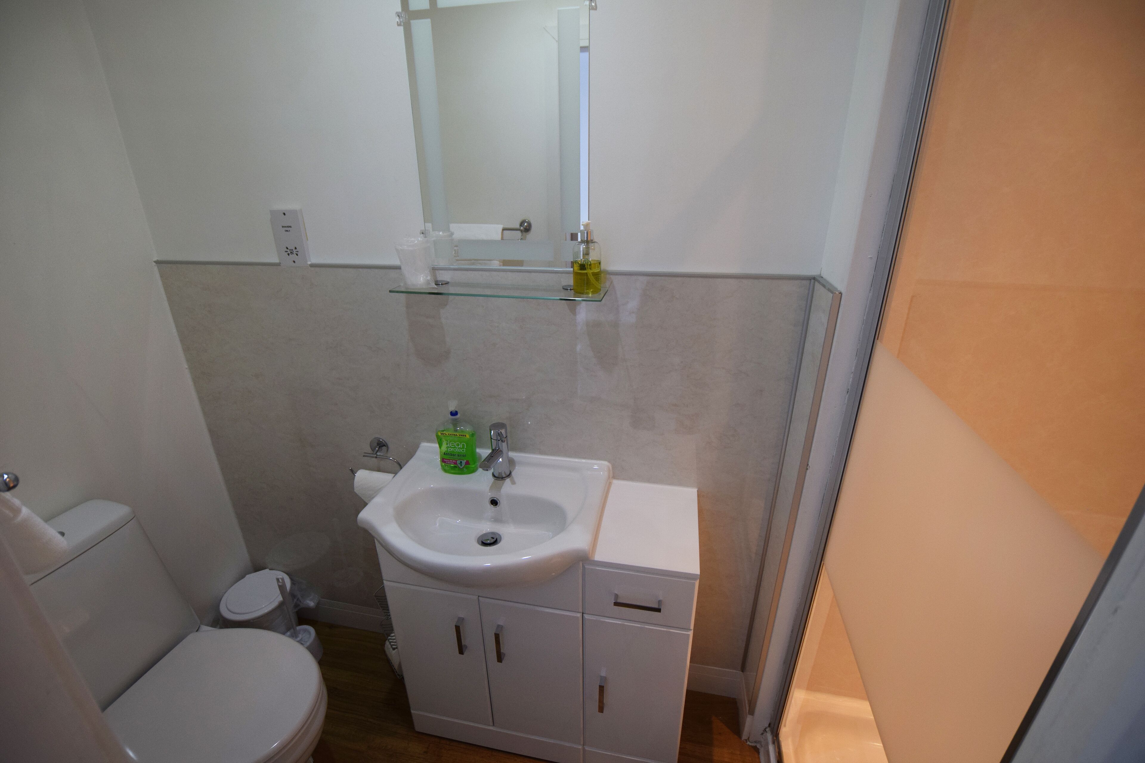 Une petite salle de bain avec des toilettes, un lavabo et un miroir.