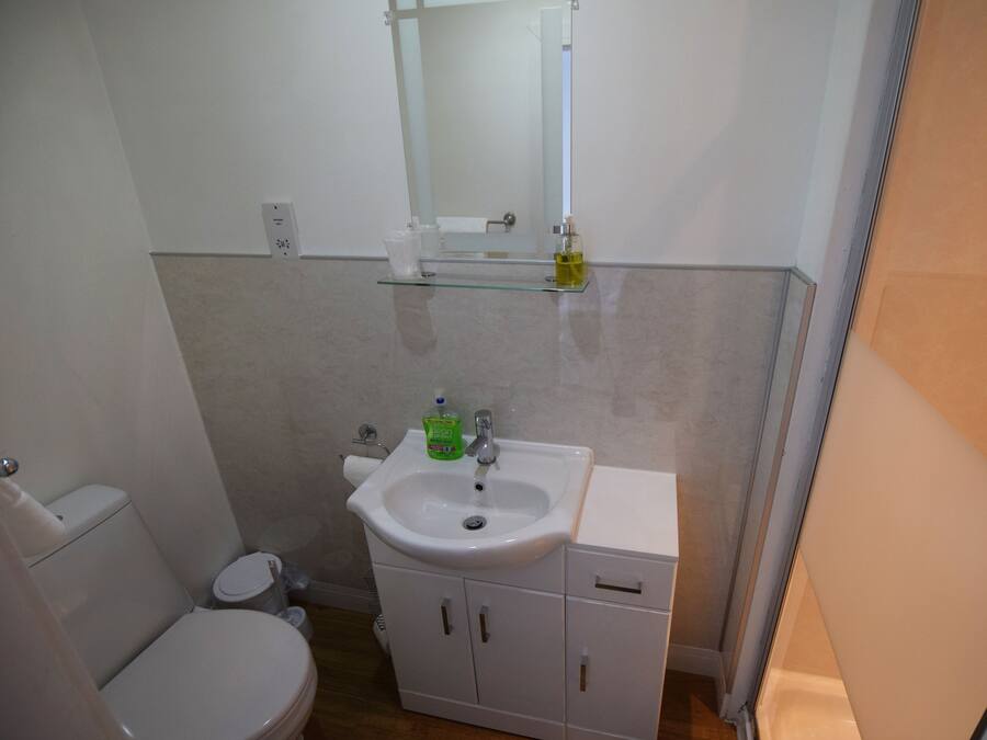 Une petite salle de bain avec des toilettes, un lavabo et un miroir.