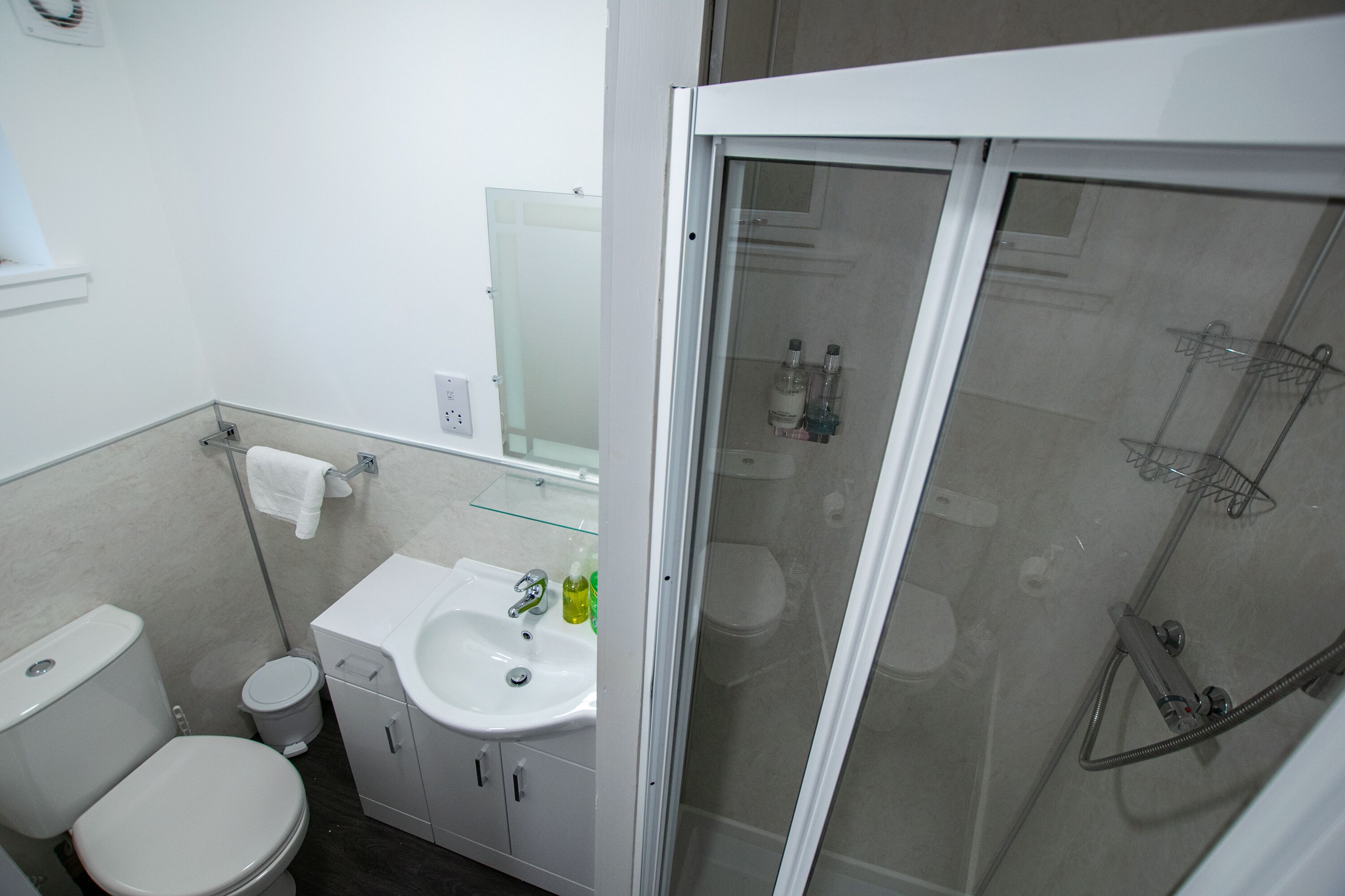 A bathroom with a toilet, sink, and shower.