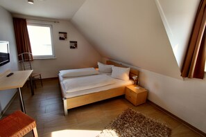 Ein Schlafzimmer mit Bett, Nachttisch, Lampe und einem kleinen Teppich.