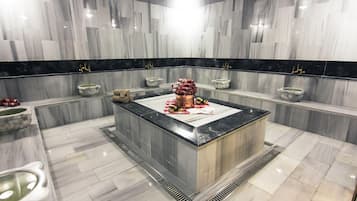 Bathroom features a central island with two sinks and a decorative flower arrangement.