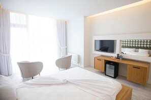 A hotel room with a bed, two chairs, a desk with a TV, and a minibar. - Ataol Can Termal Otel & Spa (Çan)