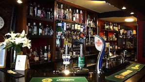 A bar area with a variety of liquor bottles, a tap labeled "PERONI", and a sign indicating "Best 3 8 HOBSONS". - The Corners Inn (Leominster)