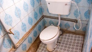 A bathroom with a toilet, blue patterned tiles, and a tiled floor. - Castle City Resort & Suites (Lekki)
