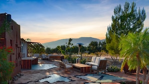An outdoor patio with hexagonal tiles, wooden furniture, and a view of mountains. - Hotel los Amantes Valle de Guadalupe (Valle de Guadalupe)