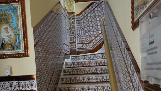A staircase with ornate white and brown patterned tiles, leading to a higher floor. - Hostal Alamare (Seville)