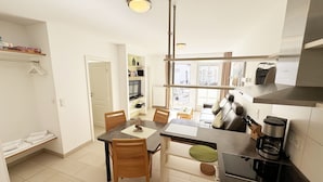 A modern kitchen with a dining area, a built-in oven, and a coffee maker. - F: House Meeresblick A 2.11 Sun deck with balcony - House Meeresblick A 2.11 (Baabe)