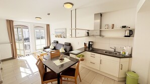 A compact apartment with a dining area, a kitchenette, and a living space. - F: House Meeresblick A 2.11 Sun deck with balcony - House Meeresblick A 2.11 (Baabe)