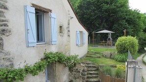 A rustic stone building with blue shutters, a small garden with a wooden fence, and a bench under a tree. - Charming house near Tours, enclosed garden, perfect for families (Montlouis-sur-Loire)