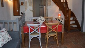 A dining area with a wooden table and chairs, a small lamp, and a staircase. - Charming house near Tours, enclosed garden, perfect for families (Montlouis-sur-Loire)