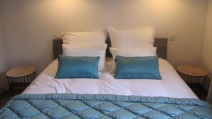 A bed with white and teal pillows, a teal quilted bedspread, and two bedside tables with lamps. - Charming house near Tours, enclosed garden, perfect for families (Montlouis-sur-Loire)