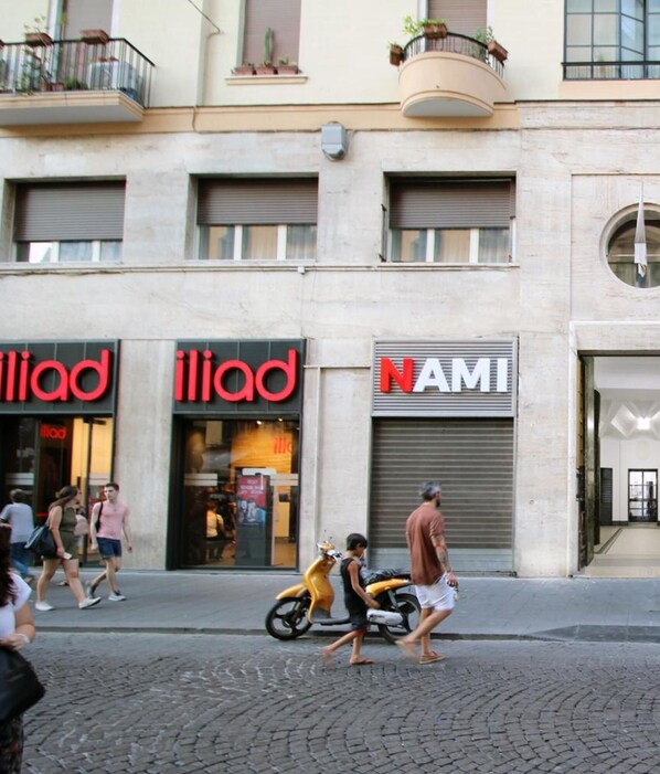 A street with storefronts, including 'iliad' and 'NAMI'.